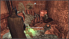 Jump over the small wall and look for a fragile wall fragment nearby the Trophy #1 - Batman trophies (17-25) | Industrial District - Industrial District - Batman: Arkham City Game Guide
