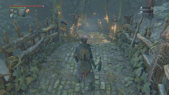 Behind the bridge, there are two enemies and a trap set on the tree to on the right side of the road. - Forbidden Woods | Walkthrough - Walkthrough - Bloodborne Game Guide & Walkthrough