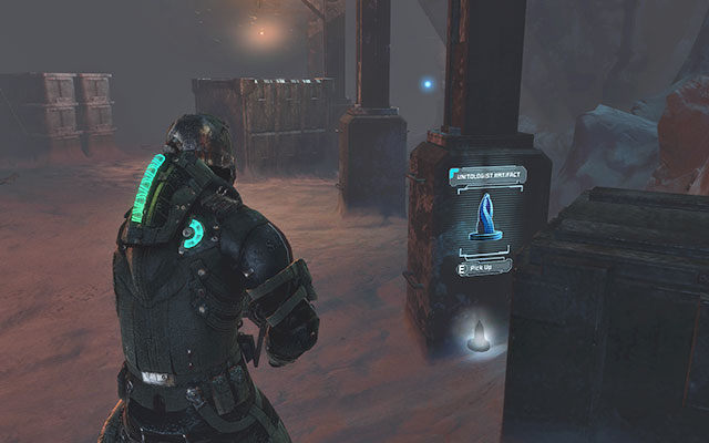 Next to one of the pillars between crates, near the cargo elevator - Chapter 14 - p. 1 | Secrets - Secrets - Dead Space 3 Game Guide