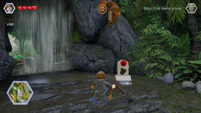 Walk to the waterfall as Paul and use the rope on the hook shown on the picture - Long Grass | Jurassic Park - The Lost World - secrets in free roam - Jurassic Park - The Lost World - secrets in free roam - LEGO Jurassic World Game Guide & Walkthrough
