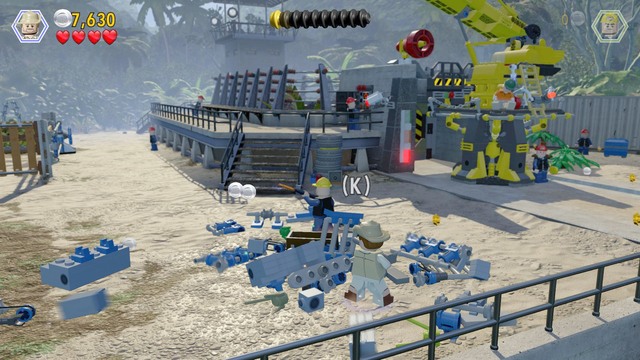 As Robert, approach the spot shown in the screenshot, smash the blue boxes and use the scattered bricks to build a bull cage - Welcome to Jurassic Park | Jurassic Park - walkthrough - Jurassic Park - walkthrough - LEGO Jurassic World Game Guide & Walkthrough