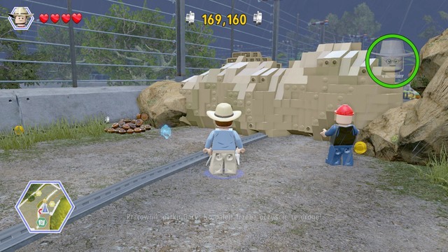 Follow the turquoise studs, up to the road block and approach it on the left - Park Shutdown | Jurassic Park - walkthrough - Jurassic Park - walkthrough - LEGO Jurassic World Game Guide & Walkthrough