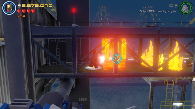 After walking to the previously opened room you must walk towards the golden barricade shown on the picture and burn it using Iron Mans lasers - Stan Lee / Red brick - Ready, A.I.M., Fire - secrets - LEGO Marvels Avengers - Game Guide and Walkthrough